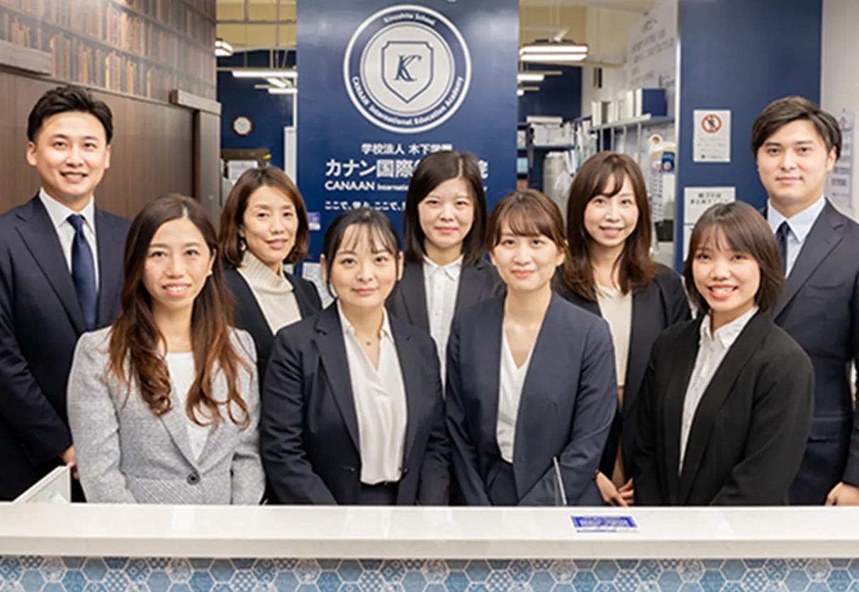 カナン国際教育学院の受付に並ぶカナングループのスタッフ集合写真