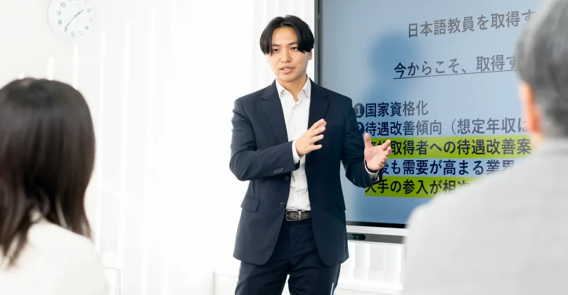 日本語学校の教室で授業を行う講師